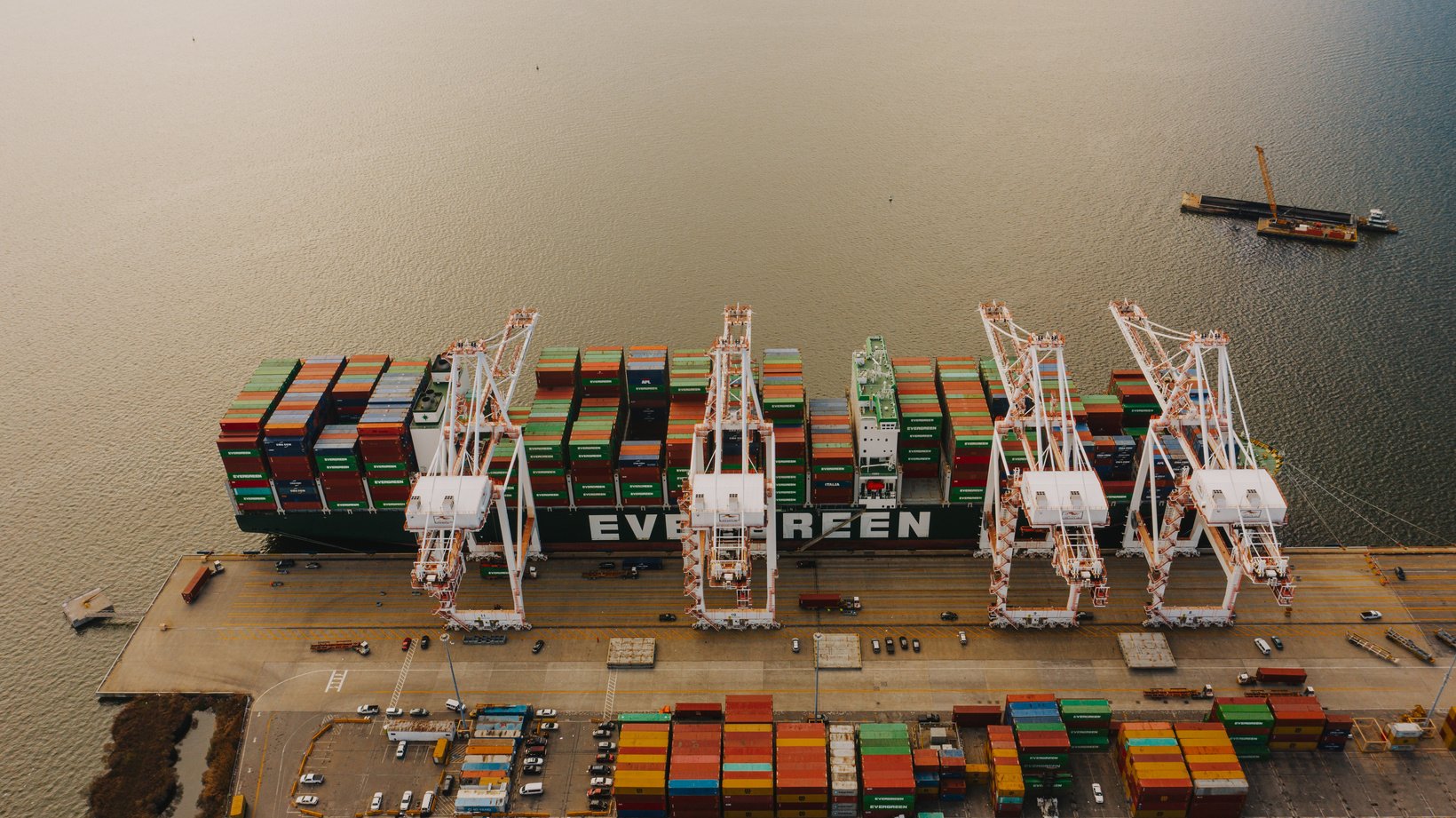 Cargo ship near pier with lifting cranes